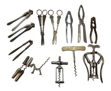 A collection of white metal items to include a James Healey and son corkscrew together with other corkscrews, nut crackers et