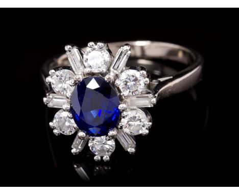 Sapphire and diamond cluster ring, the stylised flower-head cluster with a central oval mixed cut blue sapphire surrounded by