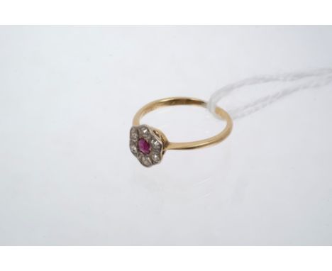 1930s ruby and diamond flower-head cluster ring with a central ruby surrounded by six old cut diamonds on plain shank.  Ring 