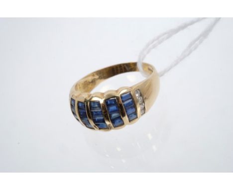 Gold (18ct) sapphire and diamond ring, the wide band with channel set baguette cut blue sapphires and diamond set shoulders, 