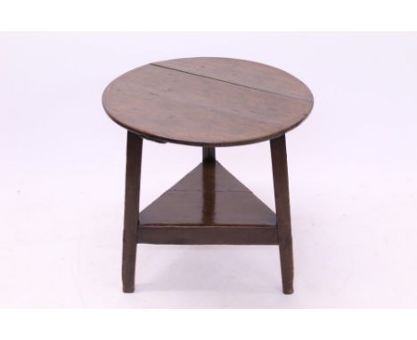 George III oak cricket table, the circular top on splayed triangular supports united by shelf undertier, 66cm diameter