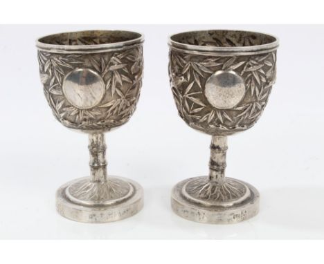 Pair late 19th / early 20th century Chinese silver egg cups with bamboo and bird decoration, on bamboo stems with circular ba