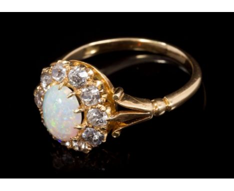 Victorian opal and diamond cluster ring with an oval cabochon opal surrounded by ten old cut diamonds in claw setting with fo