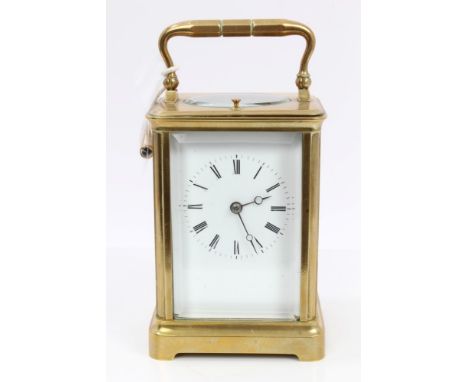 Late 19th century French repeating carriage clock in brass case with white enamelled dial and bevelled glass panels, on brack