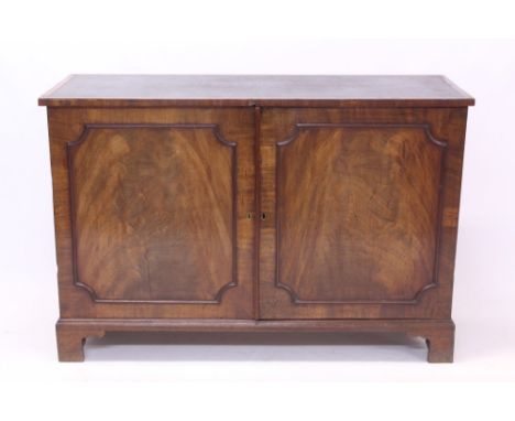 Antique figured mahogany desk with inset leather writing surface, enclosed below by pair of panelled cupboard doors with inte