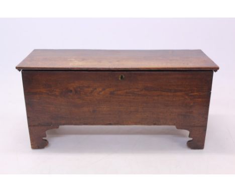 18th century elm six-plank coffer, hinged solid top enclosing interior with lidded candle box, raised on shaped bracket feet,