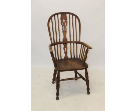 19th century ash and elm Windsor elbow chair with pierced stick back and solid saddle seat raised on turned splayed supports 