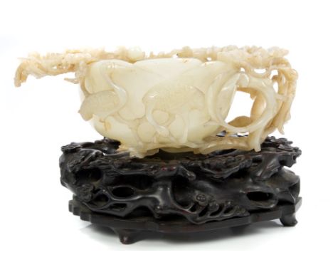 Fine quality 19th century Chinese carved and pierced jade lotus-form libation cup, the cup encircled by meandering prunus bra