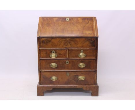 Early 18th century walnut featherbanded bureau of small proportions, the butterfly veneered hinged fall enclosing fitted step