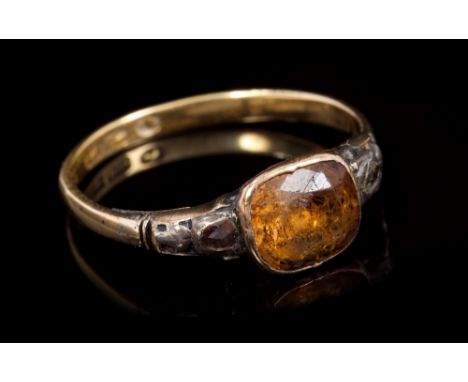 Georgian dress ring with a foil-back orange stone with a rose cut diamond to each shoulder, on a later Victorian shank.  Ring