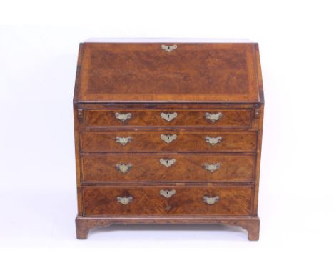 George II walnut crossbanded and featherbanded bureau - the sloping fall enclosing fitted interior of short drawers and pigeo