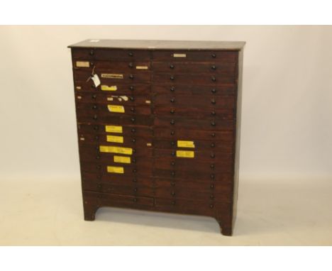 Early 20th century pine museum display cabinet, having two banks of fifteen drawers, each with glazed cover, on bracket feet,