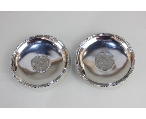 A pair of Chinese white metal dishes, both with Hong Kong 1975 One Dollar coin inset, marked Wai Kee Sterling Silver Made in 