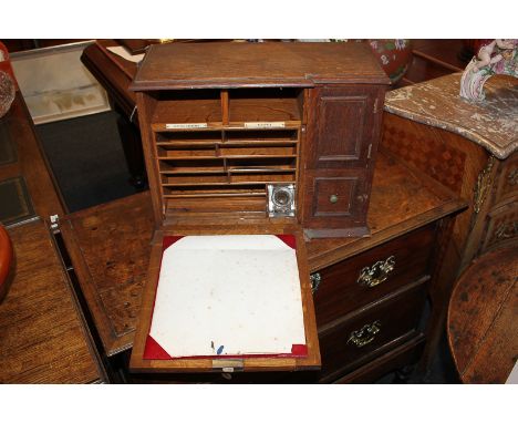 An oak table top writing cabinet with leather inset drop writing flap enclosing fitted interior of pigeon holes and inkwell, 