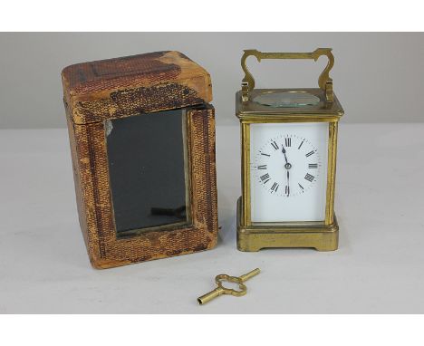 A gilt brass and bevelled glass cased carriage clock, the white rectangular dial with Roman numerals, the movement half chimi