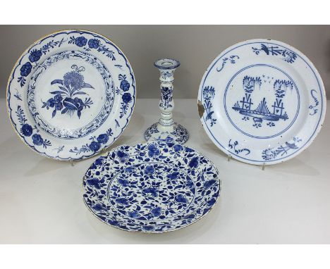 Three 19th century Delft pottery blue and white chargers together with a similar candlestick (all a/f), largest 32.5cm diamet