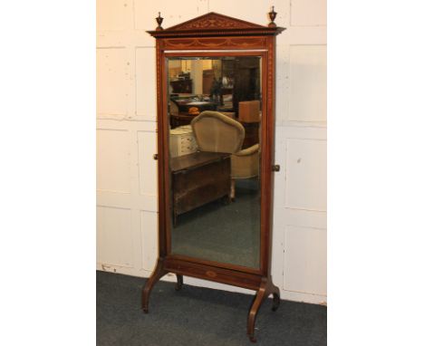 An Edwardian inlaid mahogany cheval mirror with architectural pediment flanked by urns over a bevelled rectangular mirror, on