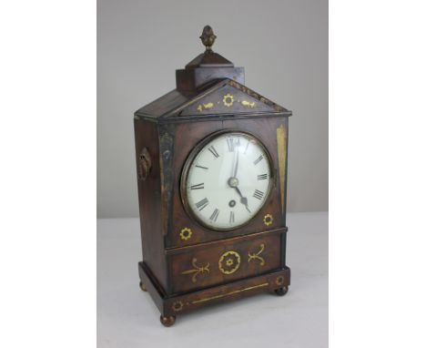 A Regency mantel clock, five inch dial with Roman numerals, with brass inlaid mahogany arched case with pineapple finial (a/f