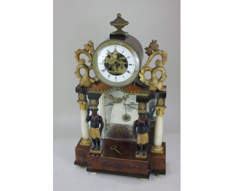 A Venetian gilt wood and metal mounted mantel clock with drum shaped dial containing the figure of a cherub blacksmith, surmo