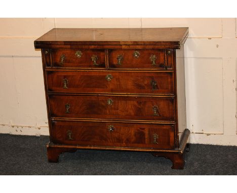 A Queen Anne style cross banded walnut bachelor's chest with fold-over rectangular top over two short and three long drawers 