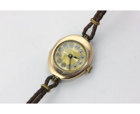 A lady's 9ct gold Rolex wrist watch with an oval case, engine turned dial and Arabic numerals, the case numbered 1189419, Lon