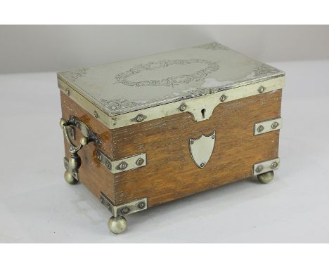 A late 19th/early 20th century silver plate mounted oak tea caddy with engraved hinged lid enclosing two lidded compartments,