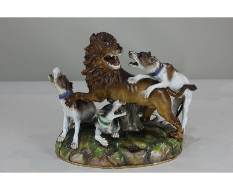 A 19th century Meissen porcelain figure of three hounds attacking a lion, with crossed sword marks to base, incised model num