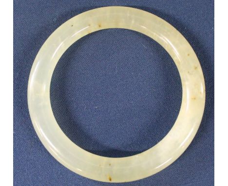 Jade type slave bangle, mottled pale green colour with brown inclusions , internal diameter 6.5cm