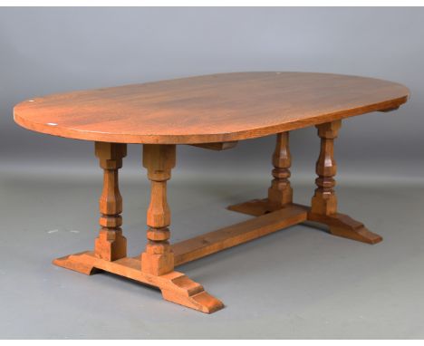 A 'Mouseman' style oak dining table, the curved top raised on octagonal baluster legs united by an 'H' bracket base, height 7