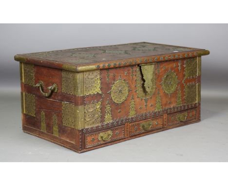 A large 20th century Zanzibar hardwood and brass mounted trunk, the hinged lid above three drawers, height 57cm, width 133cm,