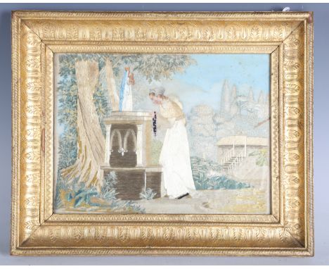 A late 18th/early 19th century silkwork and chenille panel, finely worked with a lady holding rosary beads, standing before a