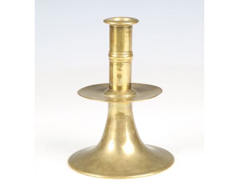 A rare 17th century English brass trumpet candlestick, circa 1660, the ribbed upper stem above a drip pan and flared circular