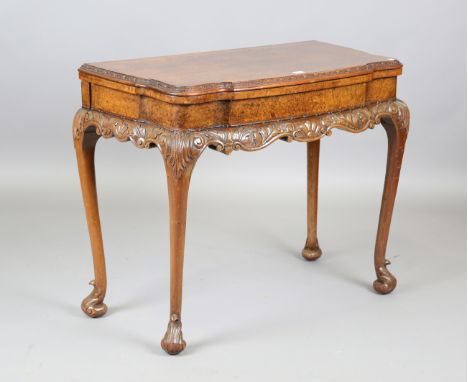 An early 20th century Queen Anne style burr walnut fold-over card table, the interior inset with a needlework panel, raised o