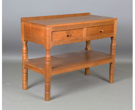 A Robert 'Mouseman' Thompson workshop oak side table, the adzed top above two drawers and an undertier, one leg carved with t