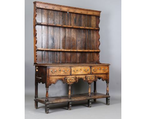 An 18th century provincial oak and elm dresser, the later shelf rack above three drawers, two dummy drawers and a pot shelf, 