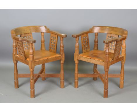 A pair of Robert 'Mouseman' Thompson workshop oak tub back elbow chairs with carved lattice back supports and tan leather sea