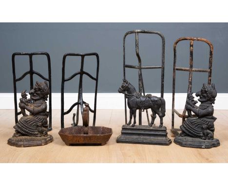 A group of four various black painted cast and wrought iron saddle racks, the largest 56cm long together with two door stops 