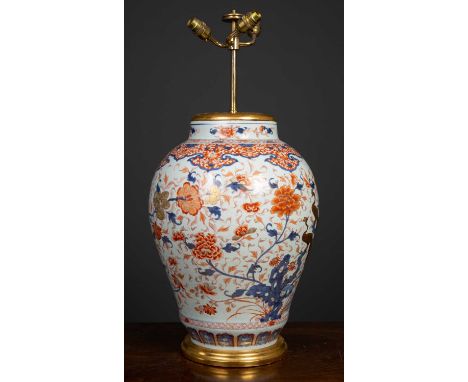 An antique porcelain large baluster jar converted to a table lamp, in imari colors, the white ground covered in blue and red 