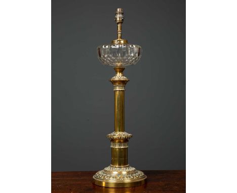 A Victorian brass based oil lamp with cut glass reservoir, later converted for use as an electric table lamp, the column supp