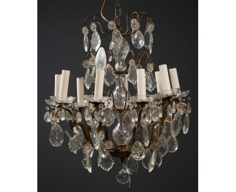 A French nine-light chandelier, with four layers of hanging glass pendants on central glass turned column, the candle sconces