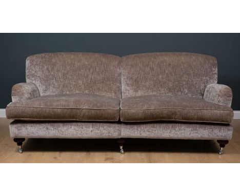 A contemporary large sofa with grey upholstered deep seat and turned tapering front legs terminating in white metal casters, 