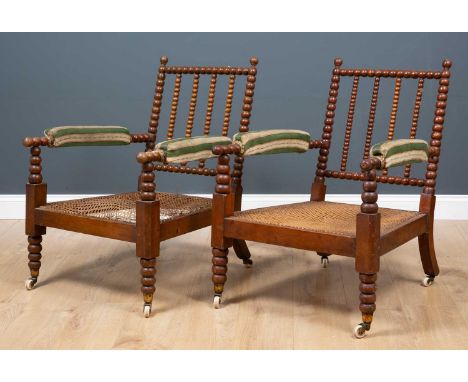 A pair of early 20th century Art and Crafts caned bobbin turned armchairs, with green and white striped upholstery, 65cm wide