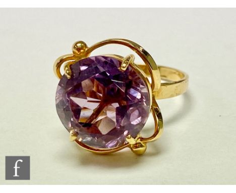 An 18ct single stone amethyst ring, circular claw set stones, diameter 14mm, to a scroll head  and plain shank, weight 7.2g, 