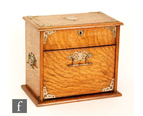 A late Victorian light oak stationery cabinet with fitted divisioned interior and cantilever fall front action, plated mounts