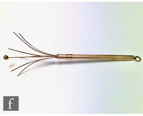 An Art Deco 9ct gold swizzle stick, engine decoration with ball terminal and pendant loop, length 8cm, weight 6g, Birmingham 