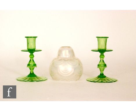 A pair of early 20th Century glass candlesticks by John Walsh Walsh, each with wide circular wrythen moulded foot below a bal