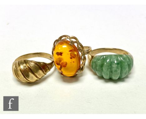 Three 9ct hallmarked rings, a single stone amber, a jade set example and a 9ct gold ribbed ring, total weight 14.5g, ring siz