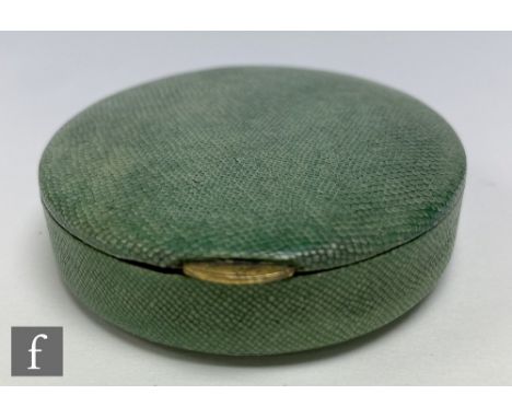 A 1930s French Art Deco shagreen powder compact of circular section with a hinged lid concealing a mirror and powder puff to 