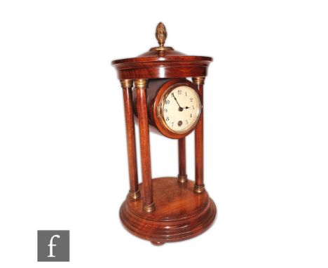 An Edwardian mahogany mantle clock, the circular enameled dial in a rotunda style pillar case on stepped base, height 34cm. 
