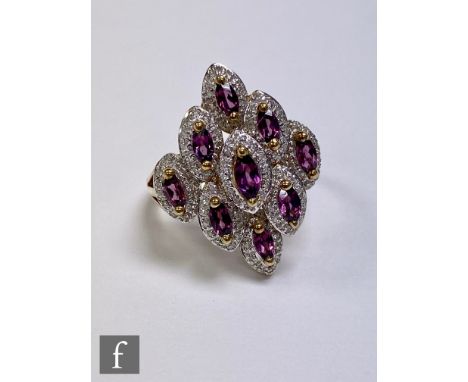 A 9ct rhodolite and diamond cluster ring comprising nine marquise cut rhodolites each within a diamond surround, all to split